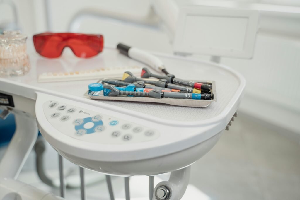 Assortment of dental tools and devices on a clinic table.